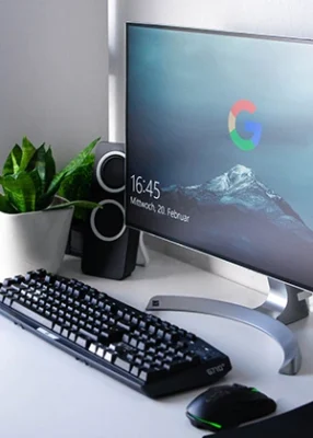 Kompjuterski monitor sa google logom na displeju ispred monitora su miš i tastatura