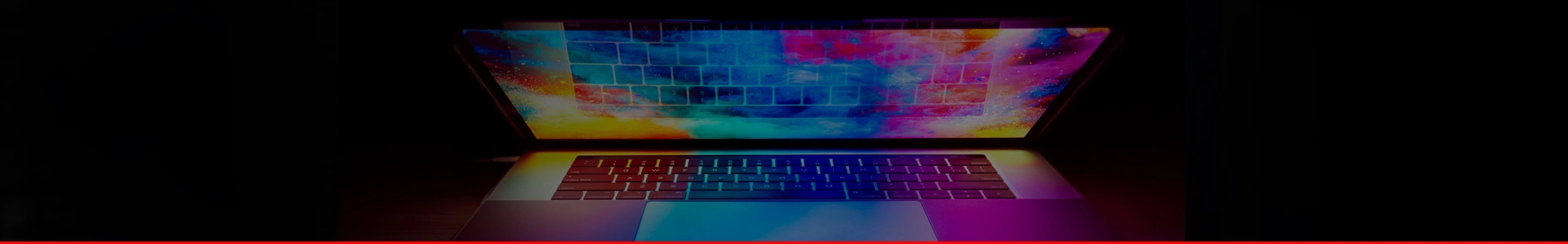 Polu otvoren laptop na mračnoj pozadini sa šarenom slikom na ekranu